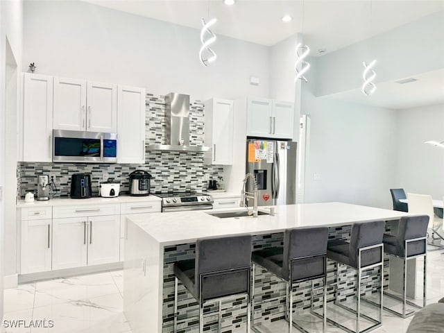 1719 NW 15th St, Cape Coral, FL 33993 - kitchen with stainless steel appliances, a sink, wall chimney range hood, a kitchen island with sink, and light marble finish floors