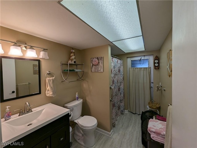 11397 Argentine Ct, Bokeelia, FL 33922 - bathroom with wood finished floors, vanity, toilet, baseboards, and curtained shower