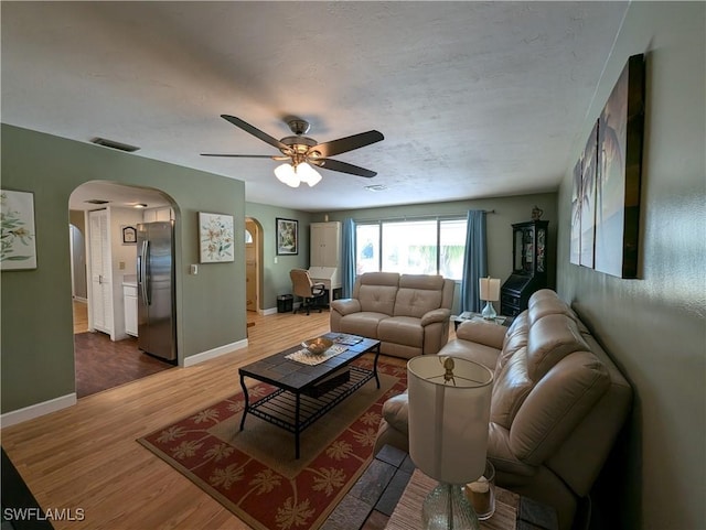 11397 Argentine Ct, Bokeelia, FL 33922 - living room with arched walkways, wood finished floors, ceiling fan, and baseboards