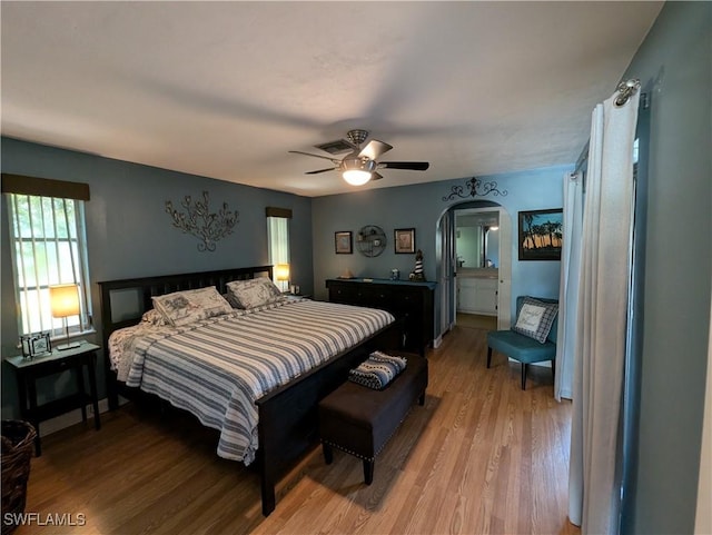 11397 Argentine Ct, Bokeelia, FL 33922 - bedroom featuring light wood-type flooring, multiple windows, arched walkways, and a ceiling fan