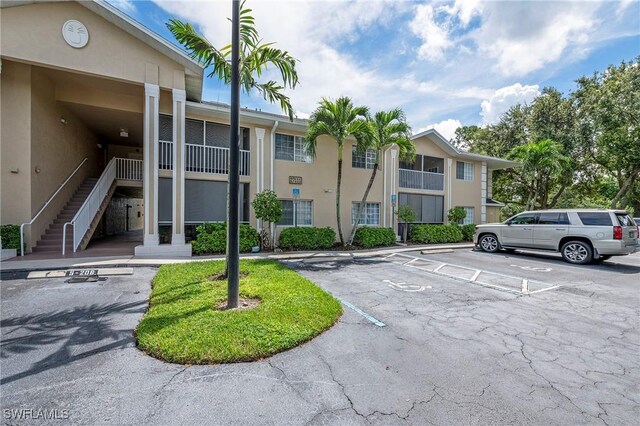 27111 Matheson Ave Unit 103, Bonita Springs, FL 34135 - view of building exterior with uncovered parking and stairway