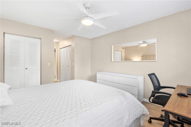 1150 Wildwood Lakes Blvd Unit 203, Naples, FL 34104 - bedroom with wood finished floors, two closets, an office area, baseboards, and ceiling fan