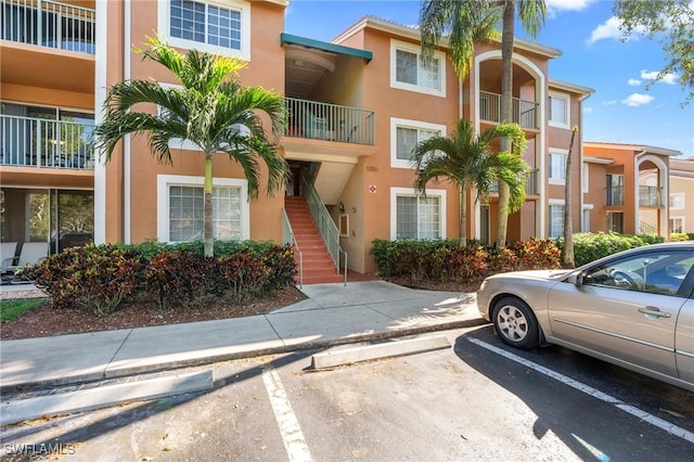1150 Wildwood Lakes Blvd Unit 203, Naples, FL 34104 - view of property featuring uncovered parking and stairway
