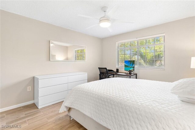 1150 Wildwood Lakes Blvd Unit 203, Naples, FL 34104 - bedroom with light wood-style floors, multiple windows, baseboards, and ceiling fan