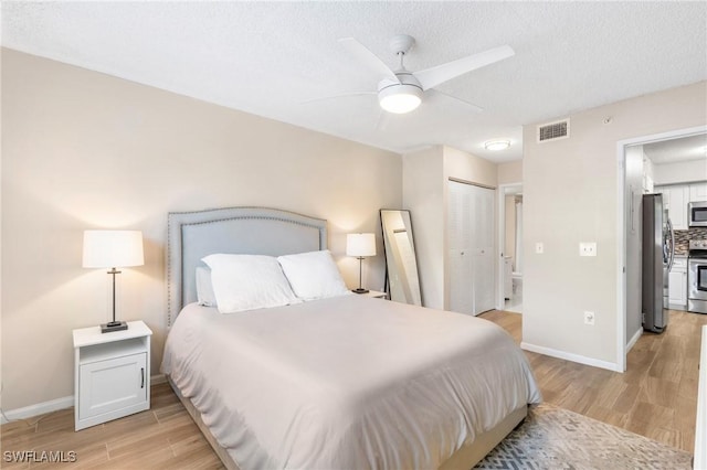 1150 Wildwood Lakes Blvd Unit 203, Naples, FL 34104 - bedroom with freestanding refrigerator, light wood-style floors, baseboards, a closet, and ceiling fan