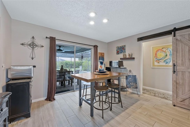 3822 Palm Tree Blvd, Cape Coral, FL 33904 - dining space featuring a barn door, wood tiled floors, a textured ceiling, baseboards, and recessed lighting
