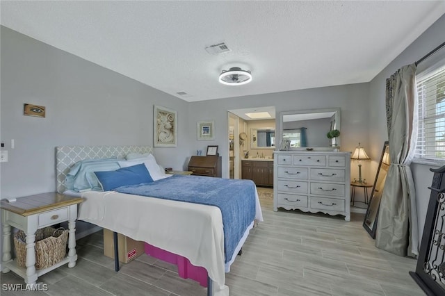 3822 Palm Tree Blvd, Cape Coral, FL 33904 - bedroom featuring a textured ceiling, wood tiled floors, and ensuite bathroom