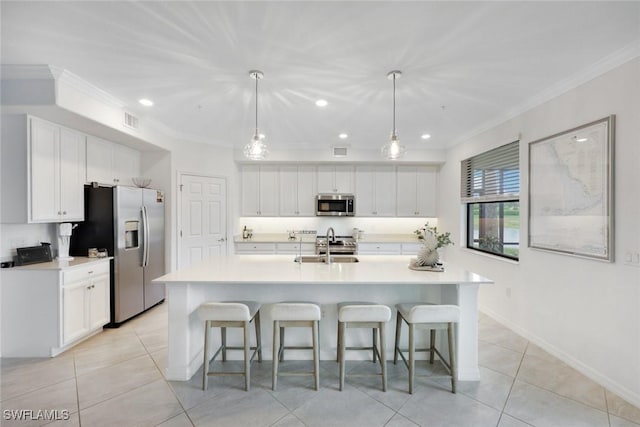 12003 Hawthorn Lake Dr Unit 101, Fort Myers, FL 33913 - kitchen with stainless steel appliances, crown molding, white cabinets, light tile patterned floors, and a breakfast bar area