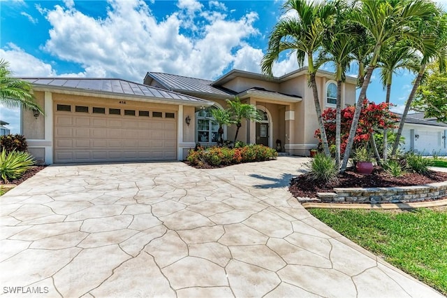 414 Caicos Dr, Punta Gorda, FL 33950 - view of front of house featuring a standing seam roof, stucco siding, concrete driveway, a garage, and metal roof