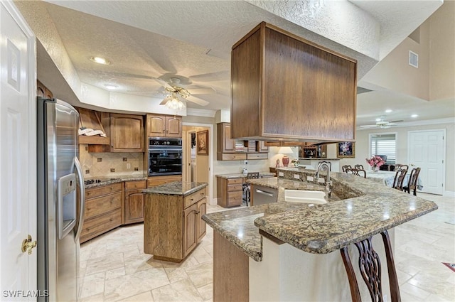 414 Caicos Dr, Punta Gorda, FL 33950 - kitchen featuring black appliances, a ceiling fan, a sink, a peninsula, and a kitchen island