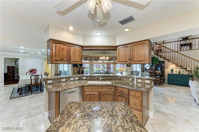 414 Caicos Dr, Punta Gorda, FL 33950 - kitchen with ceiling fan, a sink, stainless steel dishwasher, brown cabinets, and a textured ceiling