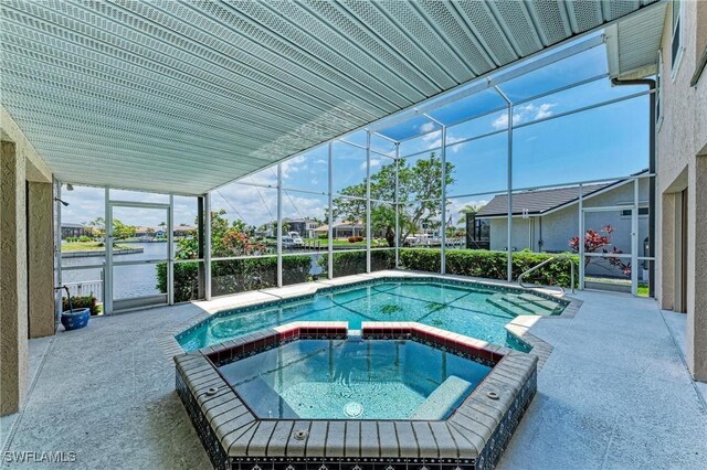 414 Caicos Dr, Punta Gorda, FL 33950 - view of pool with a water view, a pool with connected hot tub, and glass enclosure