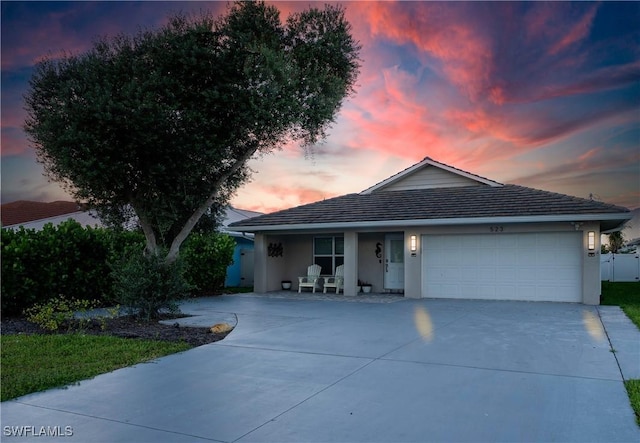 523 107th Ave N, Naples, FL 34108 - ranch-style house with stucco siding, a garage, and concrete driveway