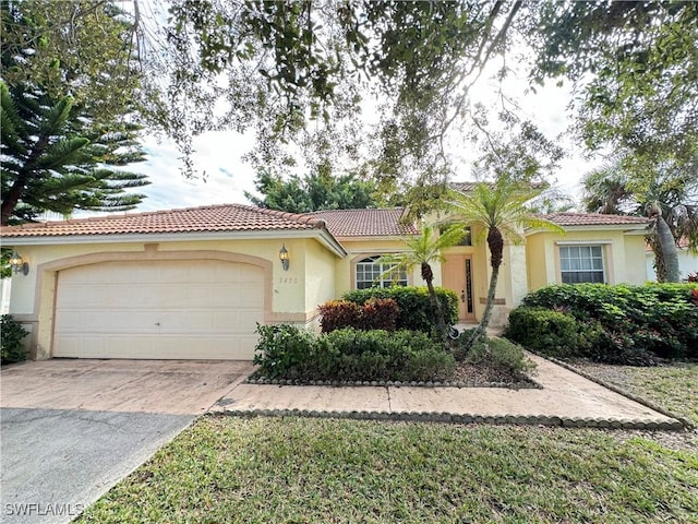 3430 Allegheny Ct, Naples, FL 34120 - view of front facade with an attached garage, a tiled roof, concrete driveway, and stucco siding