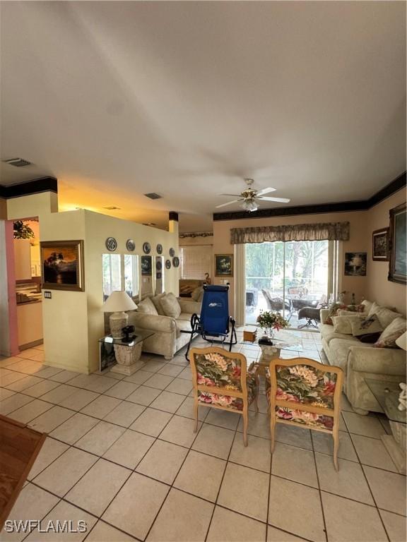3430 Allegheny Ct, Naples, FL 34120 - living room with light tile patterned floors, ceiling fan, and ornamental molding