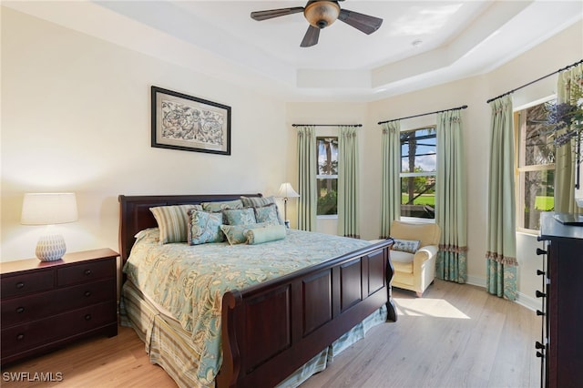 6492 Caldecott Dr, Naples, FL 34113 - bedroom featuring a tray ceiling, light wood-style floors, baseboards, and ceiling fan