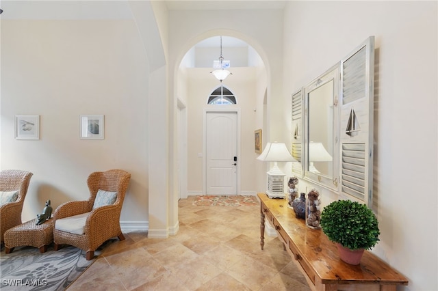 6492 Caldecott Dr, Naples, FL 34113 - entrance foyer with arched walkways, a high ceiling, and baseboards