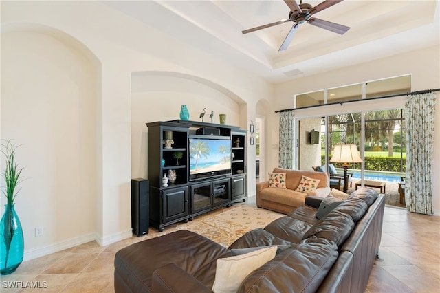6492 Caldecott Dr, Naples, FL 34113 - tiled living room with arched walkways, a raised ceiling, a ceiling fan, and baseboards