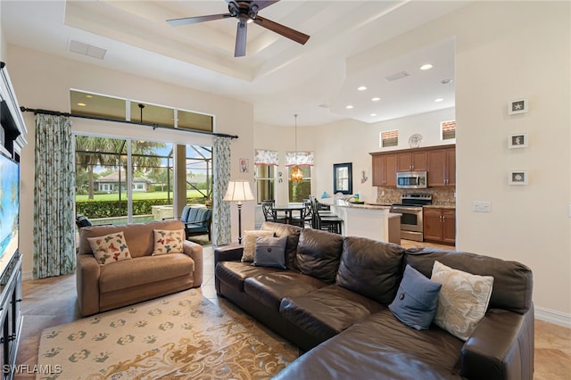 6492 Caldecott Dr, Naples, FL 34113 - living room featuring a ceiling fan, baseboards, a raised ceiling, recessed lighting, and a high ceiling