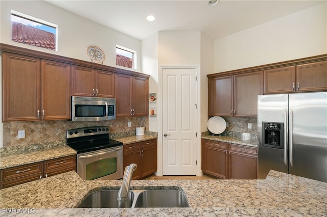 6492 Caldecott Dr, Naples, FL 34113 - kitchen with appliances with stainless steel finishes, a sink, light stone countertops, decorative backsplash, and recessed lighting