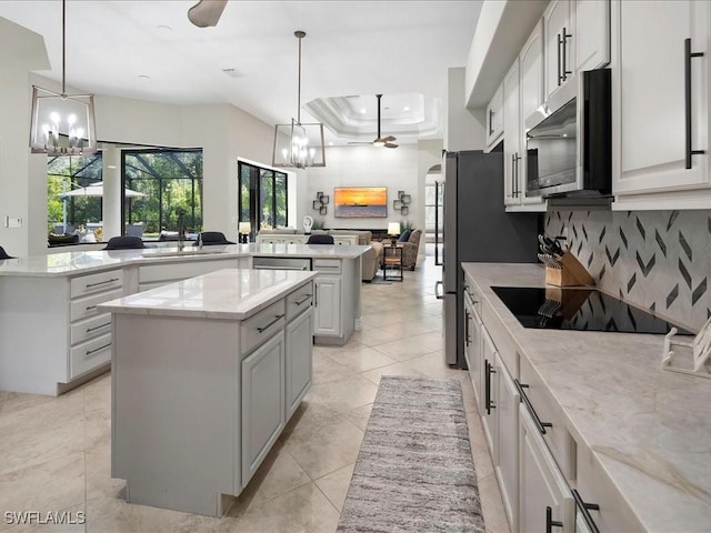 2360 19th St SW, Naples, FL 34117 - kitchen with a chandelier, stainless steel appliances, a center island, a sink, and decorative backsplash
