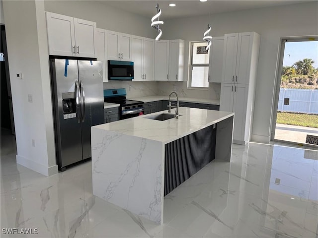 951 Commodore St, Lehigh Acres, FL 33974 - kitchen with stainless steel appliances, a sink, light stone countertops, a kitchen island with sink, and light marble finish floors