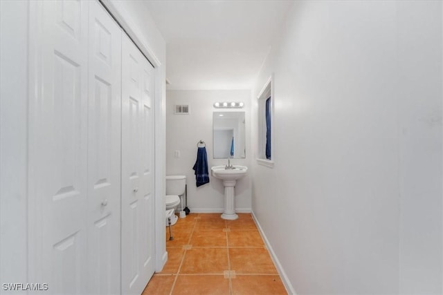 434 Leawood Cir, Naples, FL 34104 - half bath with toilet, a closet, tile patterned floors, baseboards, and a sink
