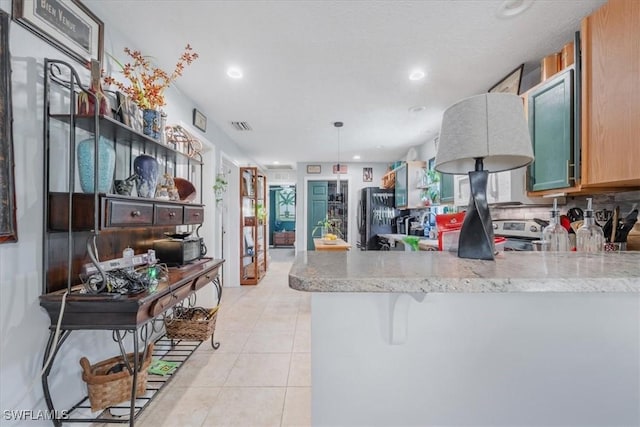 434 Leawood Cir, Naples, FL 34104 - kitchen featuring a peninsula, freestanding refrigerator, light tile patterned flooring, stainless steel electric range, and recessed lighting