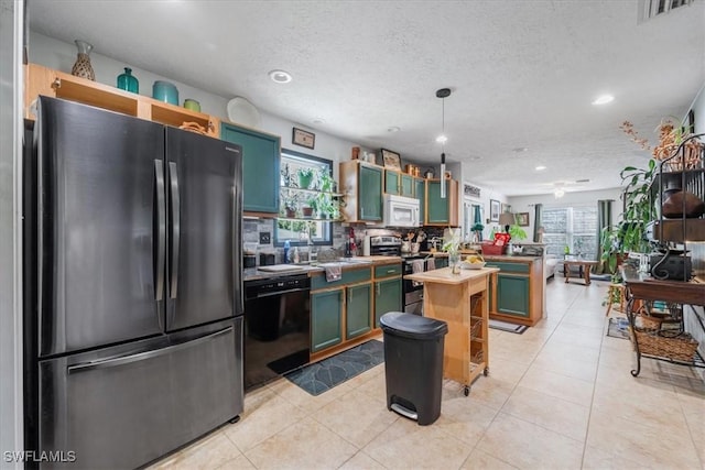 434 Leawood Cir, Naples, FL 34104 - kitchen featuring appliances with stainless steel finishes, healthy amount of natural light, recessed lighting, a textured ceiling, and light tile patterned floors