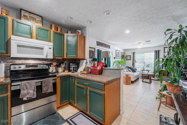 434 Leawood Cir, Naples, FL 34104 - kitchen featuring white microwave, stainless steel range with electric stovetop, green cabinets, and a textured ceiling