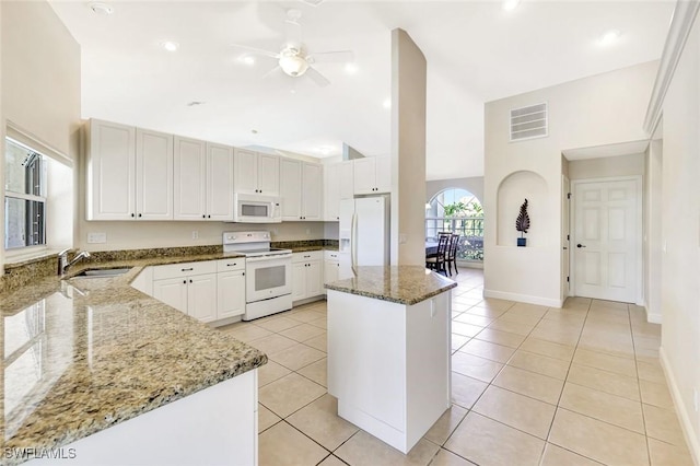 3317 SW 5th Pl, Cape Coral, FL 33914 - kitchen featuring white appliances, lofted ceiling, dark stone countertops, a ceiling fan, and a kitchen island