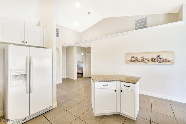 3317 SW 5th Pl, Cape Coral, FL 33914 - kitchen with white fridge with ice dispenser, light tile patterned floors, white cabinetry, lofted ceiling, and light stone countertops