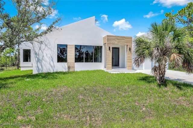 14074 Whittier Ln, Port Charlotte, FL 33981 - modern home with a front lawn, stucco siding, and driveway