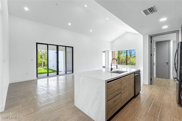 14074 Whittier Ln, Port Charlotte, FL 33981 - kitchen featuring open floor plan, modern cabinets, light wood finished floors, a kitchen island with sink, and lofted ceiling