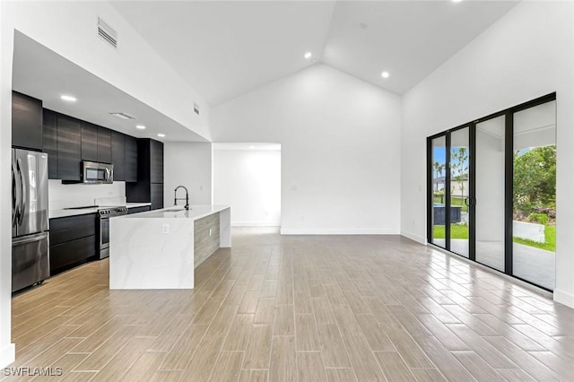 14074 Whittier Ln, Port Charlotte, FL 33981 - kitchen featuring modern cabinets, stainless steel appliances, light countertops, high vaulted ceiling, and a center island with sink