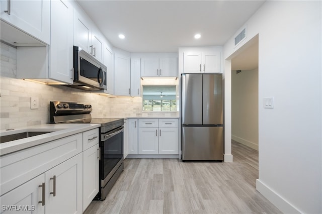 1830 Brantley Rd Unit A2, Fort Myers, FL 33907 - kitchen with appliances with stainless steel finishes, white cabinetry, decorative backsplash, baseboards, and light countertops