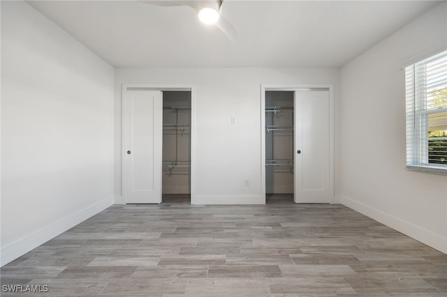 1830 Brantley Rd Unit A2, Fort Myers, FL 33907 - unfurnished bedroom featuring two closets, baseboards, light wood-style floors, and ceiling fan