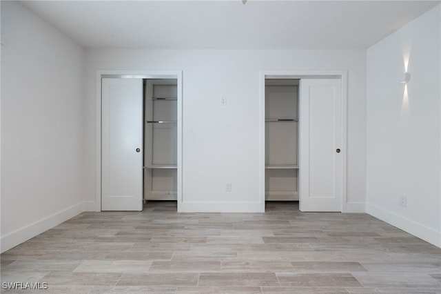 1830 Brantley Rd Unit A2, Fort Myers, FL 33907 - unfurnished bedroom featuring multiple closets, light wood-style floors, and baseboards