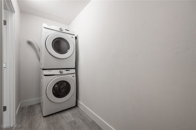 1830 Brantley Rd Unit A2, Fort Myers, FL 33907 - washroom featuring estacked washer and dryer, wood finished floors, baseboards, and a textured ceiling