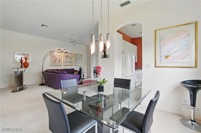878 Vistana Cir Unit 50, Naples, FL 34119 - dining space featuring a ceiling fan, arched walkways, light colored carpet, and baseboards