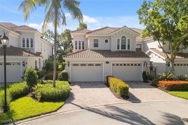 9022 Cascada Way Unit 201, Naples, FL 34114 - mediterranean / spanish-style home with a tile roof, stucco siding, driveway, and an attached garage