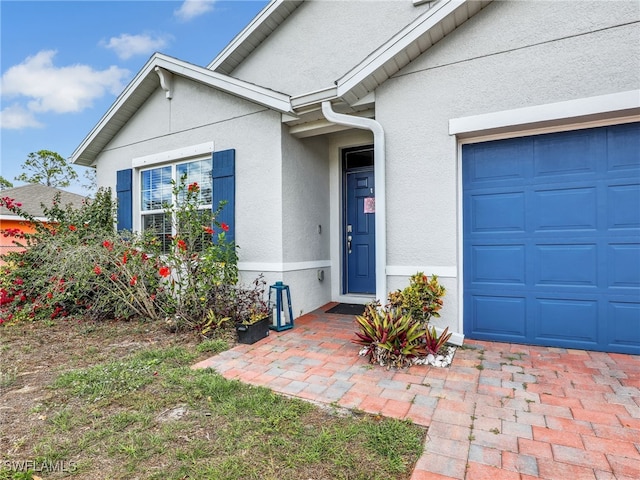 1036 Alaska Ave, Lehigh Acres, FL 33971 - doorway to property featuring stucco siding and a garage