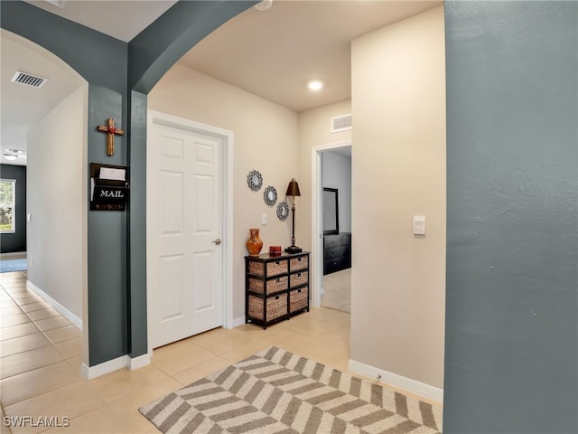 1036 Alaska Ave, Lehigh Acres, FL 33971 - corridor with arched walkways, light tile patterned floors, and baseboards