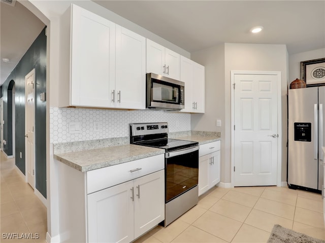 1036 Alaska Ave, Lehigh Acres, FL 33971 - kitchen with appliances with stainless steel finishes, light tile patterned flooring, light countertops, backsplash, and recessed lighting