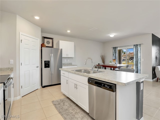 1036 Alaska Ave, Lehigh Acres, FL 33971 - kitchen featuring stainless steel appliances, a sink, light tile patterned floors, a center island with sink, and light countertops