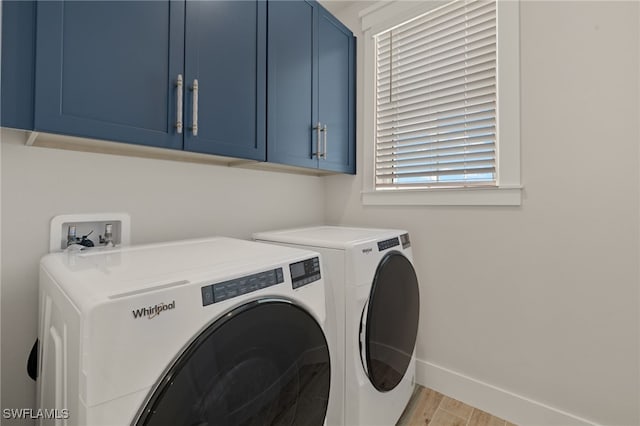 5583 Estero Blvd, Fort Myers Beach, FL 33931 - washroom featuring cabinet space, washing machine and clothes dryer, and light wood-style flooring