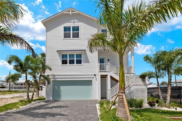 5583 Estero Blvd, Fort Myers Beach, FL 33931 - coastal inspired home featuring an attached garage, stairs, and decorative driveway