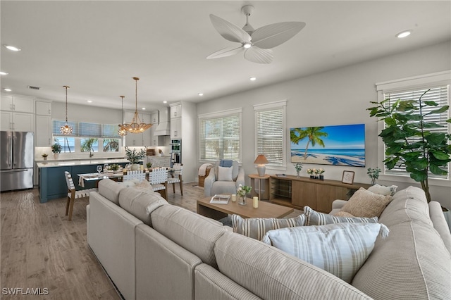 5583 Estero Blvd, Fort Myers Beach, FL 33931 - living room featuring recessed lighting, plenty of natural light, light wood-type flooring, a ceiling fan, and a chandelier