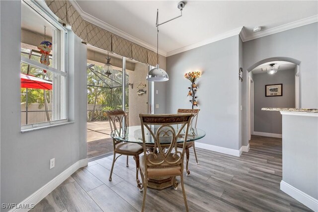 3628 NW 3rd Ter, Cape Coral, FL 33993 - dining area featuring arched walkways, healthy amount of natural light, ornamental molding, and baseboards
