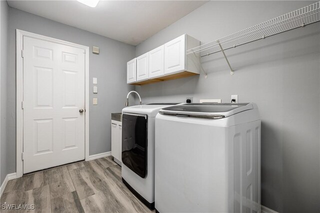 3628 NW 3rd Ter, Cape Coral, FL 33993 - laundry area featuring separate washer and dryer, cabinet space, light wood-type flooring, and baseboards
